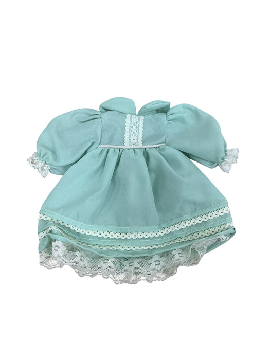 Muñeca de porcelana con vestido verde y zapatos
